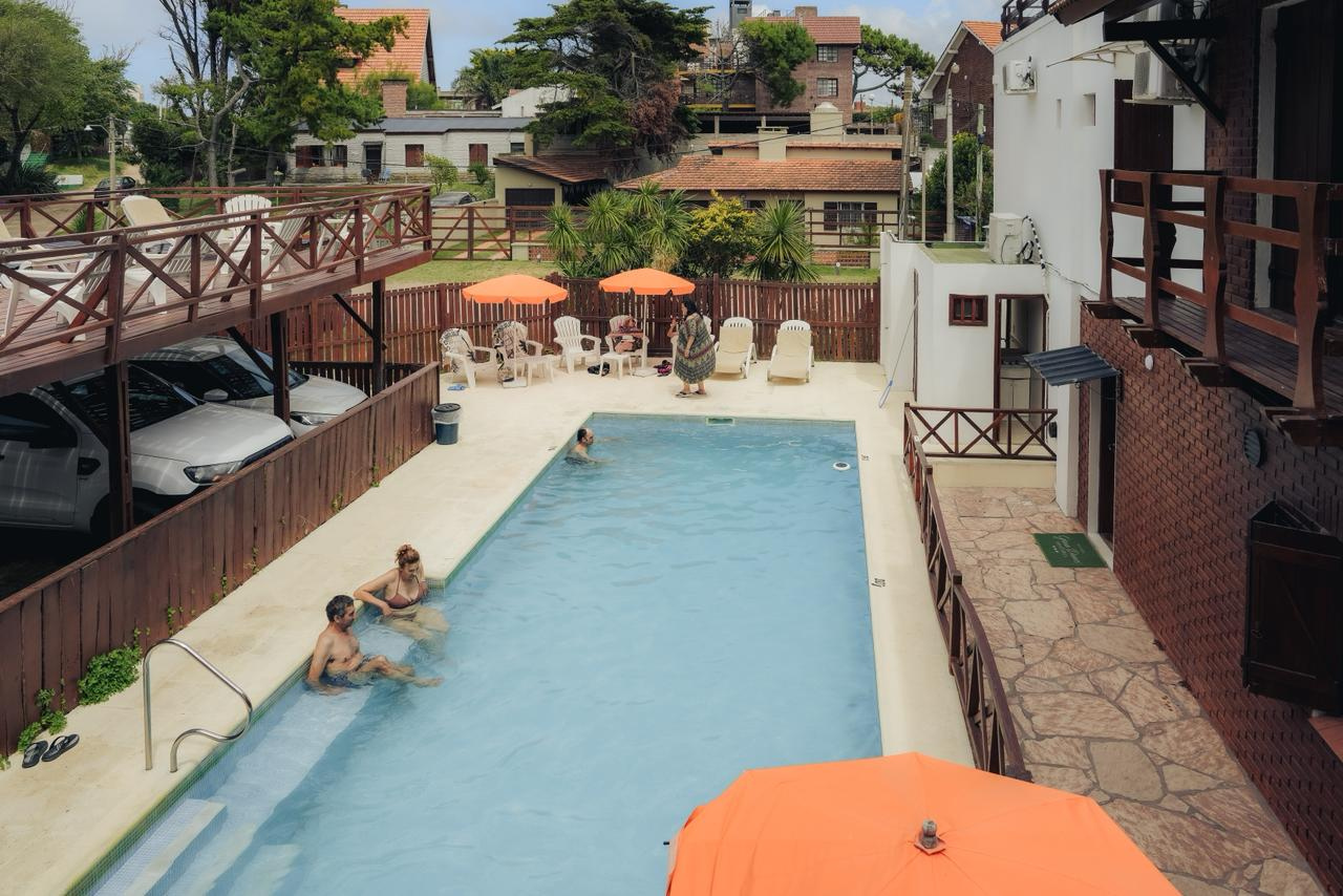Piscina climatizada de la Hostería Gran Danes en Villa Gesell, con reposeras y sombrillas
